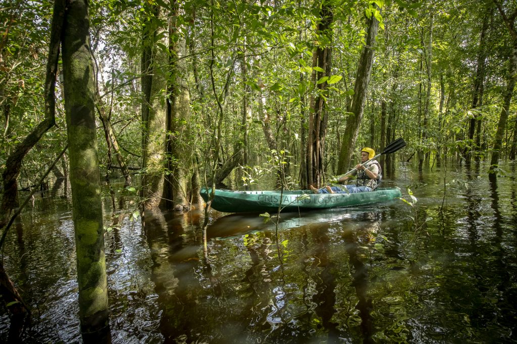 Man canoeing down the river at Cristalino Lodge in Brazil as advertised by Kiwano Hotels